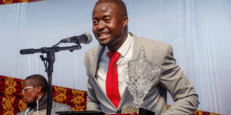 Youth advocate Bill Rogers smiles while delivering a speech and holding a crystal award after Liberia’s UN Security Council victory