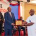 President Joseph Boakai presents a performance certificate to LACRA Director General Christopher Sankolo during the 2024 PMCS awards ceremony in Monrovia.
