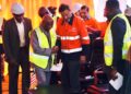 President Joseph Nyuma Boakai shakes hands with ArcelorMittal Executive Chairman Lakshmi Mittal during the inauguration of the $1.8 billion iron ore concentrator in Tokadeh, Nimba County, surrounded by executives and engineers in safety gear