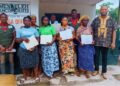 Women and youth in Bong County proudly hold land deeds awarded by Menleleh Incorporated during land rights ceremony