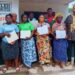 Women and youth in Bong County proudly hold land deeds awarded by Menleleh Incorporated during land rights ceremony