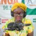 Bong County Superintendent Hawa Norris speaks into a microphone during a radio broadcast in Gbarnga, addressing misinformation and public protests.