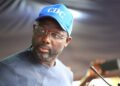 former president George Weah wearing a blue face cap with the inscription "CDC"