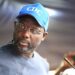 former president George Weah wearing a blue face cap with the inscription "CDC"