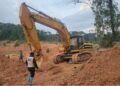 An excavator at an illegal mining site in Duogbo Town, Grand Kru County, as a Ministry of Mines official supervises its shutdown.