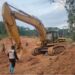 An excavator at an illegal mining site in Duogbo Town, Grand Kru County, as a Ministry of Mines official supervises its shutdown.