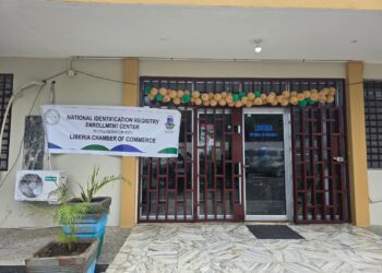 Front view of the Liberia Chamber of Commerce building in Monrovia with a banner announcing the launch of the National Identification Registry Enrollment Center.