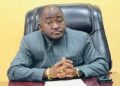 Ambassador Dee-Maxwell Saah Kemayah, Sr., seated behind a desk, hands clasped, wearing a striped traditional suit, addressing the public on Liberia’s election to the UN Security Council.”