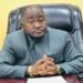 Ambassador Dee-Maxwell Saah Kemayah, Sr., seated behind a desk, hands clasped, wearing a striped traditional suit, addressing the public on Liberia’s election to the UN Security Council.”