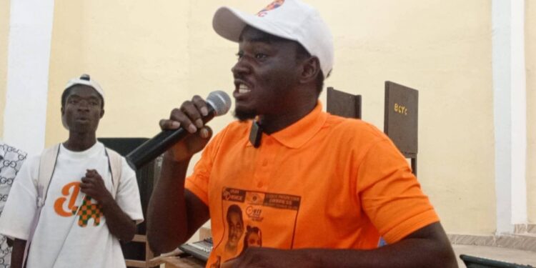 Kongoi Gborkorquellie speaks passionately during his campaign launch at Bong County Technical College, wearing an SPC shirt and cap as he outlines plans for a campus clinic.