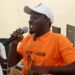Kongoi Gborkorquellie speaks passionately during his campaign launch at Bong County Technical College, wearing an SPC shirt and cap as he outlines plans for a campus clinic.