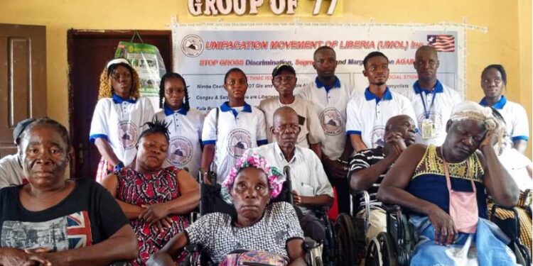 Group of 77 members, including persons with disabilities, gather for a donation ceremony with officials of the Unification Movement of Liberia at their Monrovia headquarters.