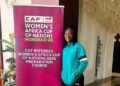 Liberian referee Hannah Moses stands beside a CAF Women’s Africa Cup of Nations preparation course banner during elite training in Cairo, Egypt.