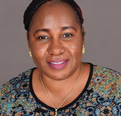 Harriette Mondaye, newly appointed Country Director for Americares Liberia, smiling in a professional portrait wearing a patterned top and gold jewelry