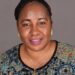 Harriette Mondaye, newly appointed Country Director for Americares Liberia, smiling in a professional portrait wearing a patterned top and gold jewelry