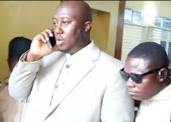 Al Hussein Fadiga, seen on the phone while being escorted by court officers, after his arrest and remand at Monrovia Central Prison on June 23, 2025, over a $1.6 million libel judgment.