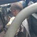 CDC Chairman Janga Kowo seated in the back of a police pickup truck, partially obscured by a riot shield and surrounded by police officers during his arrest in Monrovia.