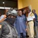 Ambassador Dee-Maxwell Saah Kemayah exits a courthouse in Monrovia surrounded by security personnel, including an armed officer in tactical gear and uniformed court officers, following his arrest in connection with a corruption investigation.