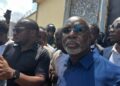 Former House Speaker J. Fonati Koffa appears in public after being released from Monrovia Central Prison, surrounded by supporters and security personnel.