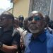 Former House Speaker J. Fonati Koffa appears in public after being released from Monrovia Central Prison, surrounded by supporters and security personnel.