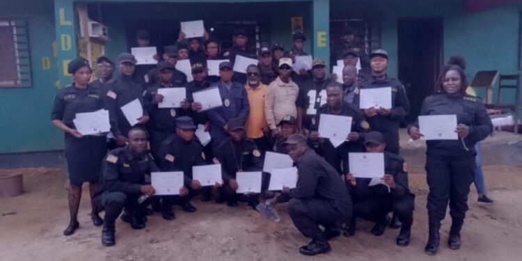 Graduating LDEA officers display training certificates in front of the Grand Gedeh County Detachment after completing specialized anti-drug training.