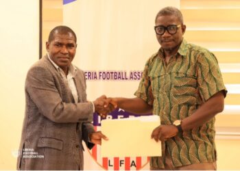 FA Deputy Secretary-General Muhammed Sheriff and NHSS Executive Director Dionysius Sebwe shake hands during the signing of a two-year grassroots football development partnership.