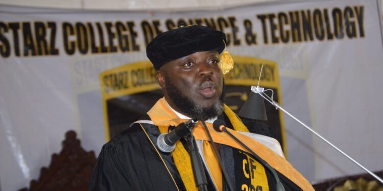 Starz University founder Ambassador Latim Da-Thong delivers a speech in academic regalia during a commencement ceremony, supporting NCHE reforms in Liberia’s higher education sector.