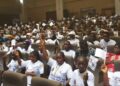 Hundreds of Liberian children raise UNICEF pamphlets at a youth gathering in Monrovia during Day of the African Child commemoration.