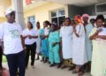 Rev. Dr. Alvin Attah of AMEU addresses a group of mothers and newborns at JFK Maternity Center after the university cleared medical bills as part of its 30th anniversary humanitarian celebration.