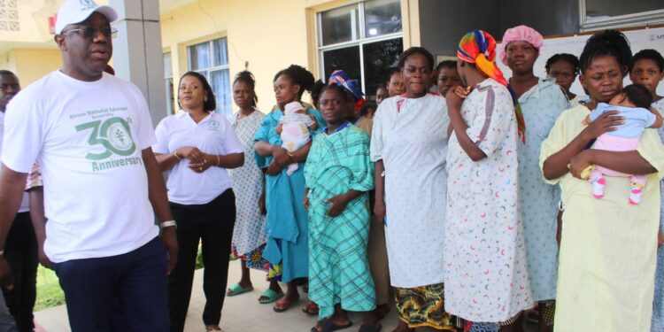 Rev. Dr. Alvin Attah of AMEU addresses a group of mothers and newborns at JFK Maternity Center after the university cleared medical bills as part of its 30th anniversary humanitarian celebration.