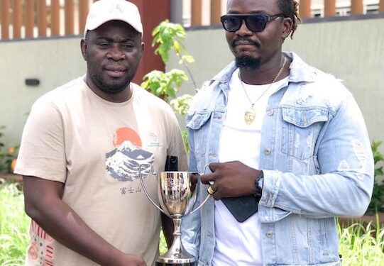 PANASA President Adekoyejo Adegbesan and NASAL President Lester Dgian Morris pose with a Scrabble trophy during a preparatory visit for the 2026 Pan African Championship in Liberia.