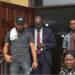 Peach H. Bility, son of Rep. Musa Bility, wearing black face cap exits Criminal Court C in Monrovia after pleading guilty to drug trafficking charges, accompanied by his lawyer and security personnel