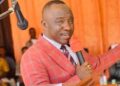 Senator Prince Moye speaking at a public event, wearing a red checkered suit and addressing political tensions in Bong County amid protest allegations.