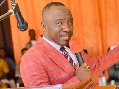 Senator Prince Moye speaking at a public event, wearing a red checkered suit and addressing political tensions in Bong County amid protest allegations.