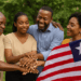 AI-generated image showing four smiling Liberian individuals—two men and two women—standing outdoors in a circle with their hands joined in a gesture of unity and reconciliation. One woman holds a visible Liberian flag, symbolizing national peace and healing, with lush green trees in the background.