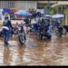 Motorbike riders wash their bikes in floodwater at the entrance of Liberia’s SKD Sports Complex, highlighting the stadium’s deteriorating condition.