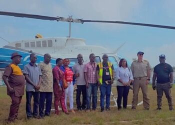 Officials from the Liberia Airport Authority, Samaritan’s Purse, and local authorities pose in front of a helicopter during the groundbreaking of the Sanniquellie Airstrip rehabilitation project in Nimba County.