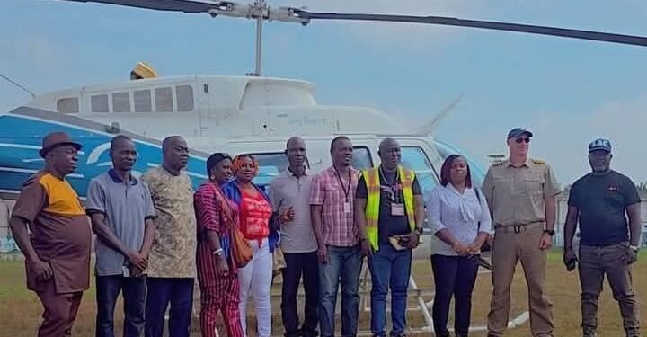 Officials from the Liberia Airport Authority, Samaritan’s Purse, and local authorities pose in front of a helicopter during the groundbreaking of the Sanniquellie Airstrip rehabilitation project in Nimba County.