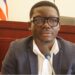 Tarnue N. Jeke, nominee for Deputy Minister for Administration at Liberia’s Ministry of Commerce, seated at a confirmation hearing before the Senate Committee, wearing a dark blazer and glasses.