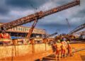 Liberian mine workers at ArcelorMittal Tokadeh site operating heavy equipment near the newly commissioned iron ore concentrator