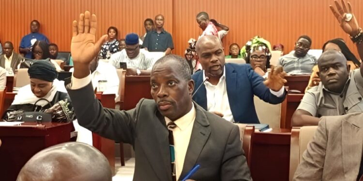 Liberian lawmakers raise hands during a legislative session at the Capitol as they review a bill seeking to reinstate oversight in county budget approvals.