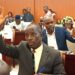 Liberian lawmakers raise hands during a legislative session at the Capitol as they review a bill seeking to reinstate oversight in county budget approvals.