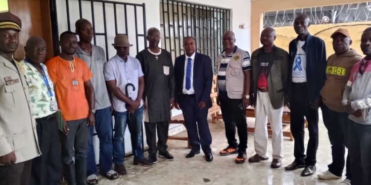 Liberian officials from the LRRRC and LIS pose with community leaders during the launch of the biometric registration for former Ivorian refugees.