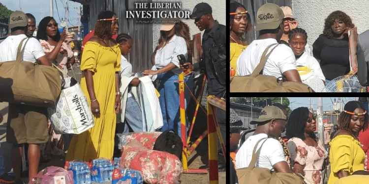Wives of imprisoned Liberian lawmakers deliver supplies including mattresses, bottled water, fans, and food items to Monrovia Central Prison. The women, joined by legislative aides and supporters, stand outside the facility in solidarity with their detained spouses amid Capitol arson charges