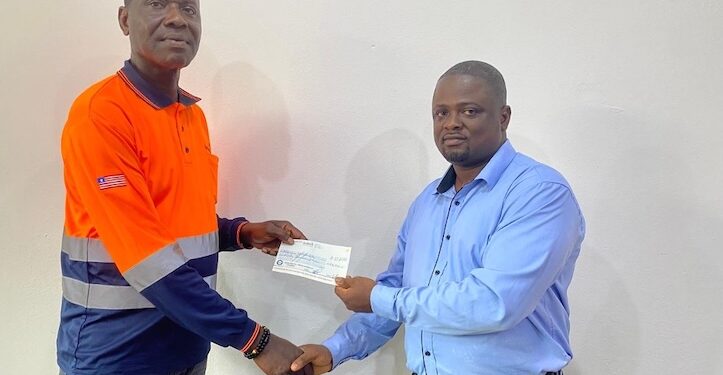 Joseph Sloan of ArcelorMittal Liberia presents a $50,000 check to Assistant Professor Emmanuel A. Donseah of Nimba University to support the school’s mining and geology program.