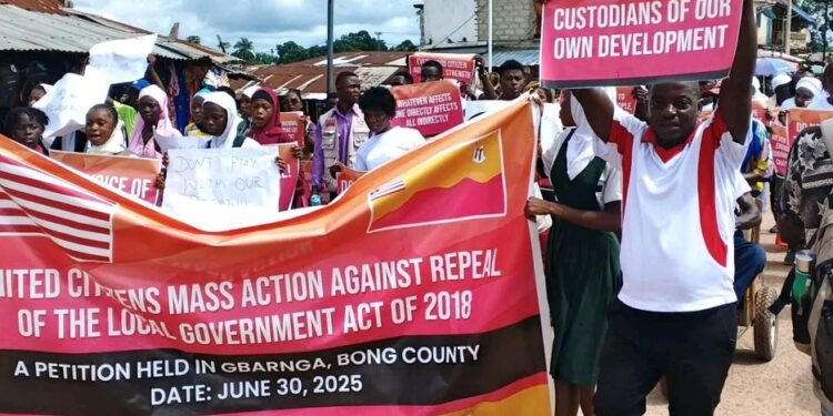 Protesters in Gbarnga march against the repeal of key sections of the 2018 Local Government Act holding banners and placards