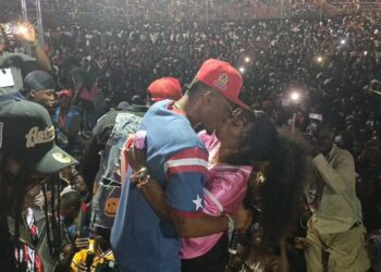 Christoph the Change kisses his wife on stage in front of a massive crowd at SKD Stadium during his historic Independence Day concert, capturing an emotional moment of love, victory, and cultural pride.