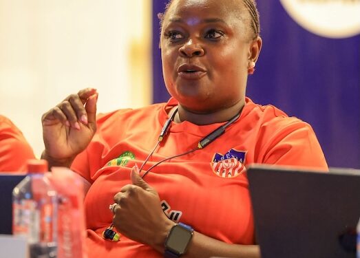 Zambian coach Florence Mwila participates in a CAF A Coaching Diploma session in Monrovia, Liberia, wearing a red training jersey with the Liberia Football Association logo.