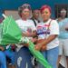 Deputy Minister Cornelia Kruah distributes green umbrellas to female market vendors during a community empowerment ceremony in New Georgia Estate, District 13.
