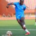 Edward Ledlum trains with the Liberian national team ahead of international fixture, wearing blue kit and preparing to strike the ball.
